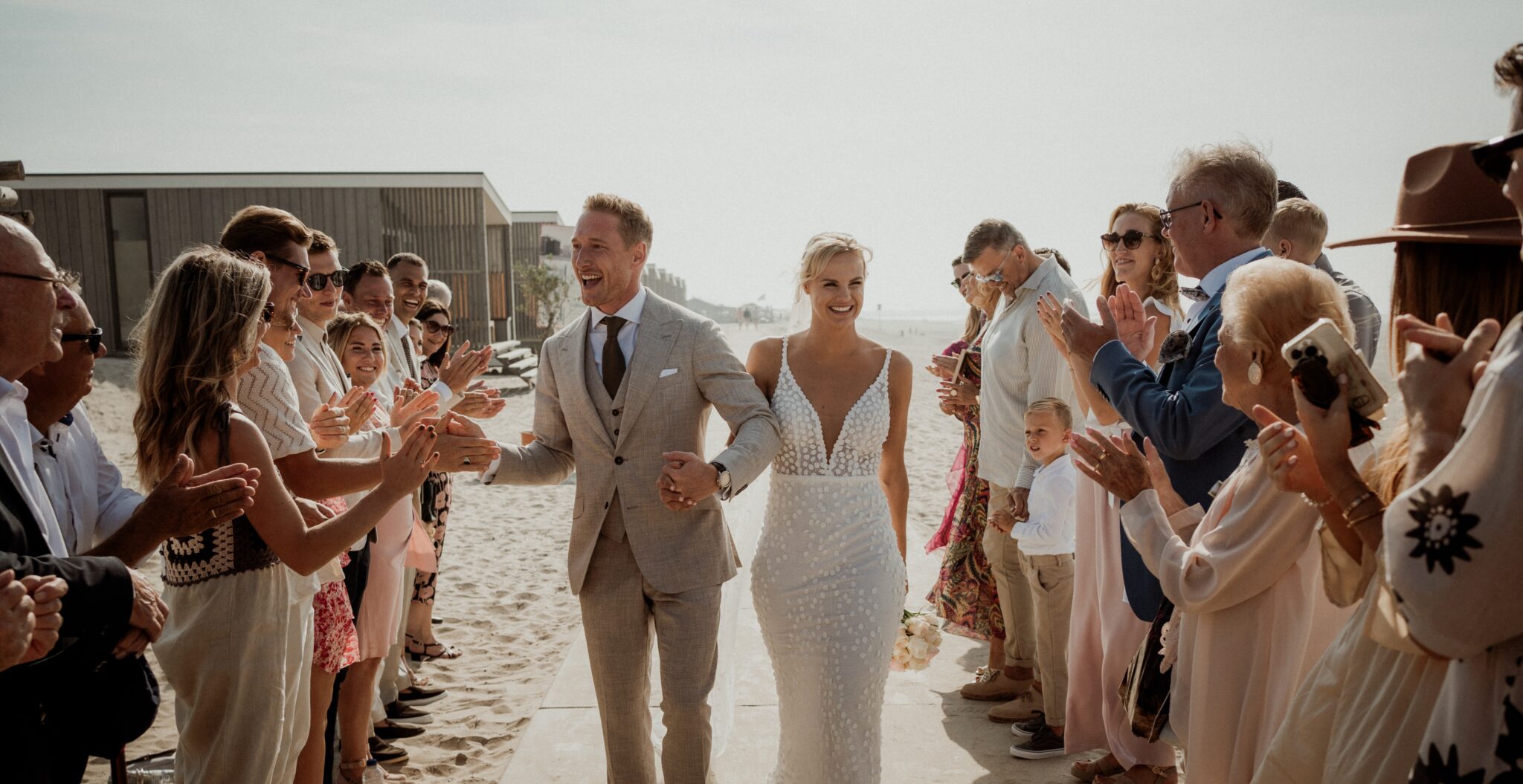 Nick en fleur lopen naar het altaar op het strand