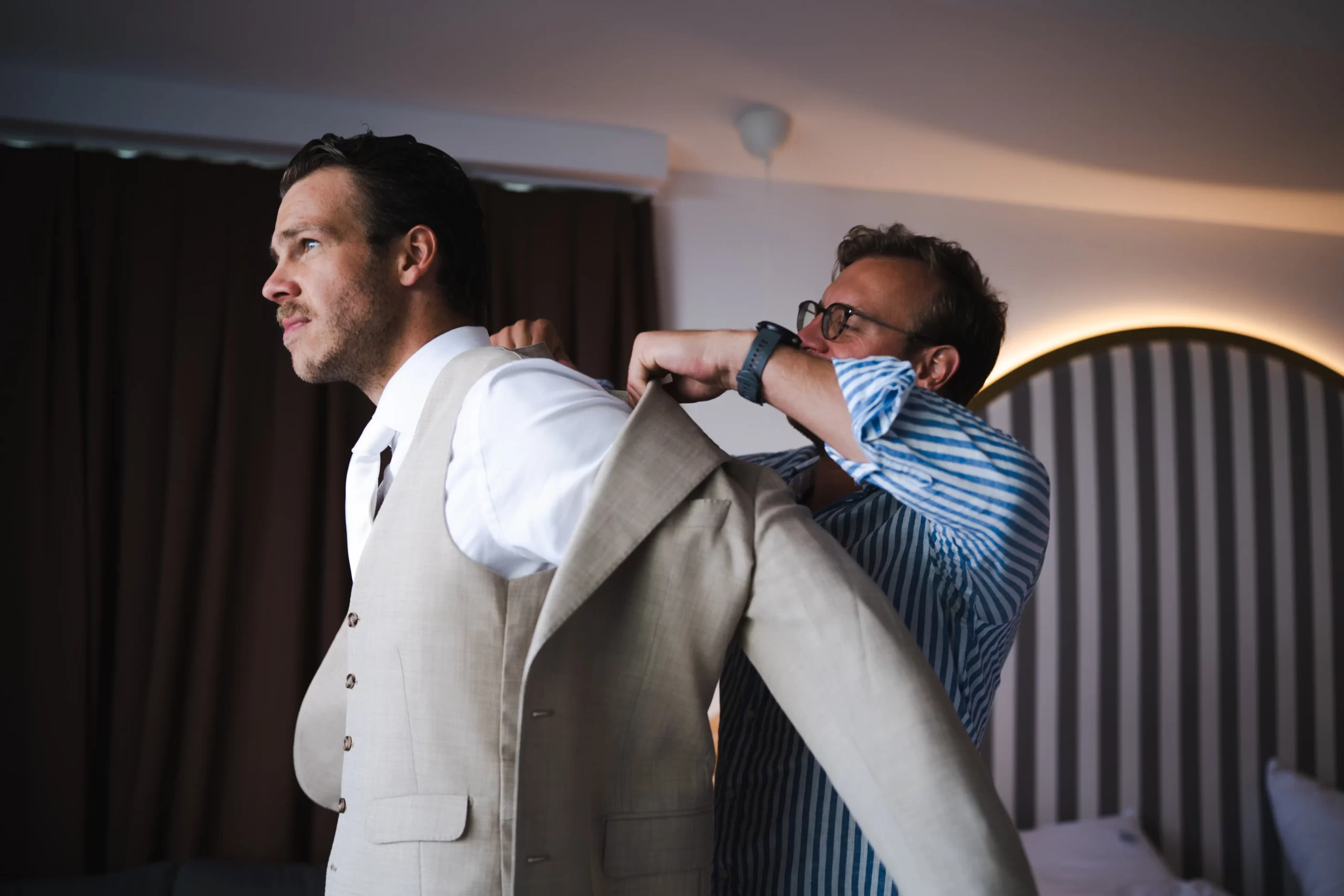 Luigi's groom Julien wordt in zijn trouwpak geholpen